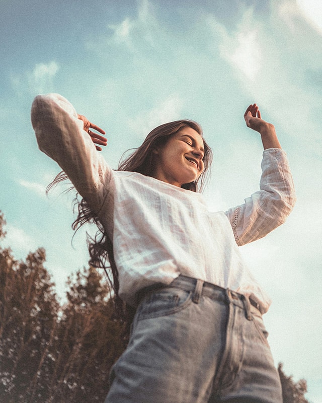 A woman stands outside and enjoys the natural surroundings, which is something clients can do at our woman's drug rehab near Richmond.