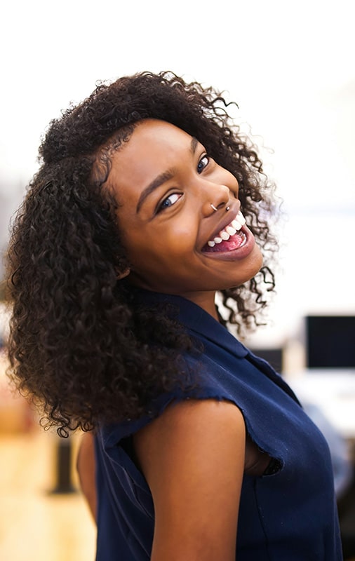 A woman smiles and faces the camera. Our women's drug rehab near Richmond can help women find improved wellbeing.