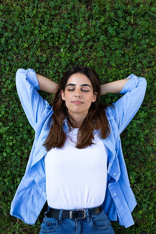 A woman lies in the grass.